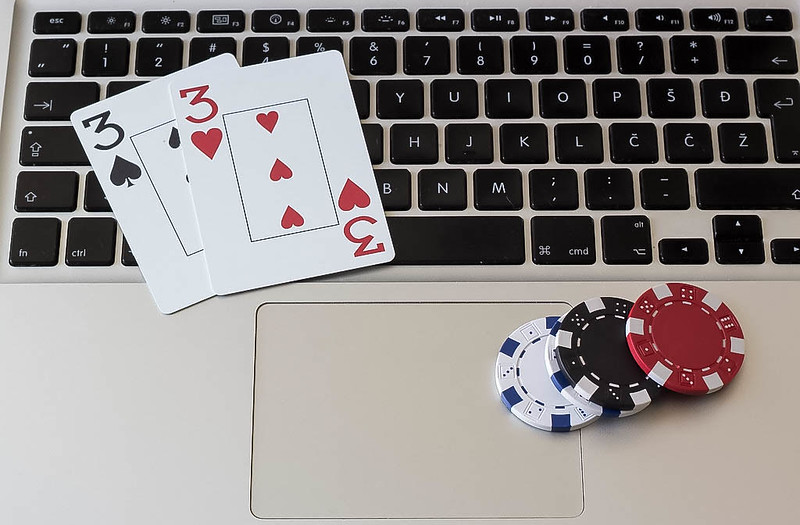 Spelkaarten en fiches op laptop, online gokken